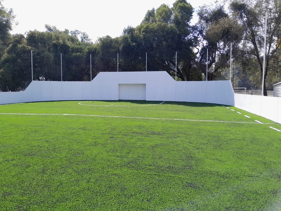 Cancha de futbol rápido con pasto sintético y muros blancos - Sportmaster
