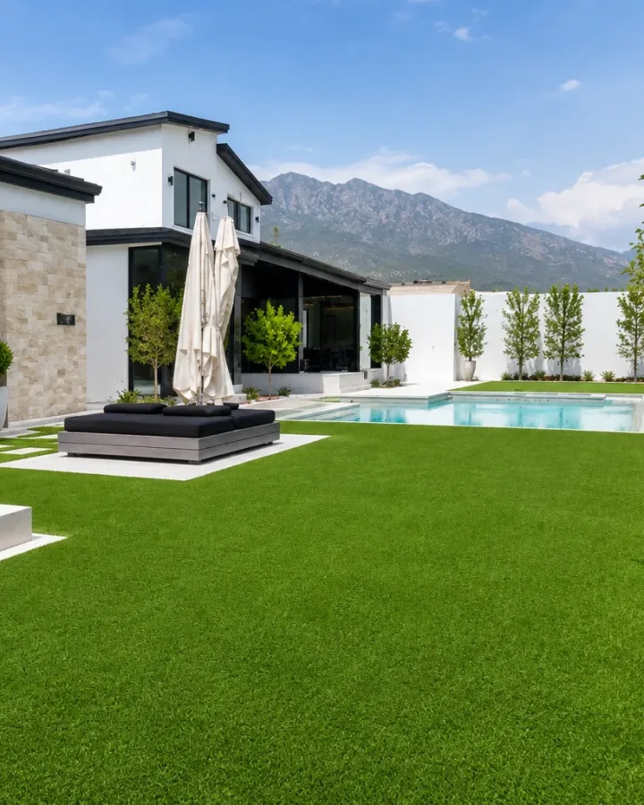 Jardín residencial con alberca y césped artificial instalado