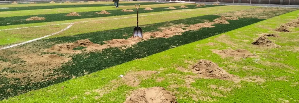 Costo de instalación de pasto sintético: relleno de arena sílica esparcido sobre el pasto de una cancha