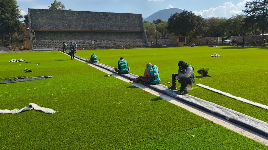 Cuanto se cobra por poner pasto sintético: cuadrilla de Sportmaster trabajando la instalación en una cancha