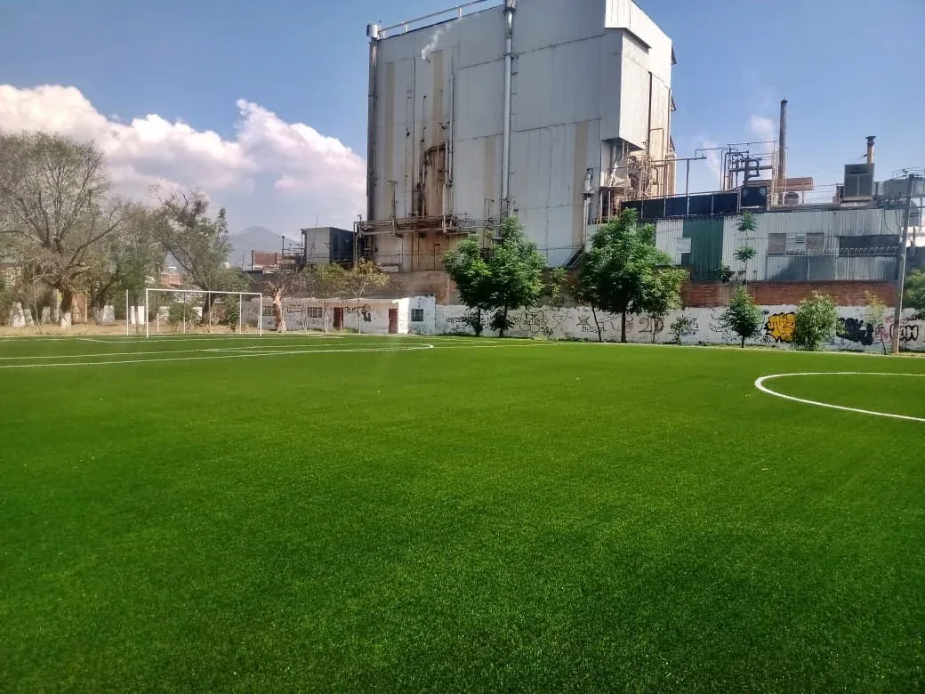 Cancha de soccer con pasto sintético del Deportivo IMDE en Morelia, Michoacán, con portería y muro perimetral