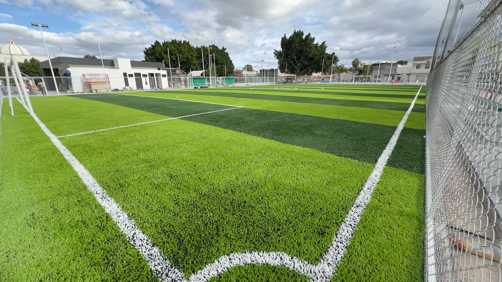 Cancha de soccer con pasto sintético a franjas y líneas de juego terminada, San Luis Potosí