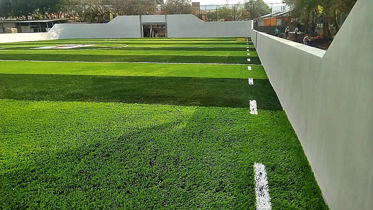 Cancha de fútbol rápido con pasto sintético en Escuela Primaria Pablo Guardado Chávez, Tuxtla Gutiérrez, Chiapas: la cancha desdel fondo