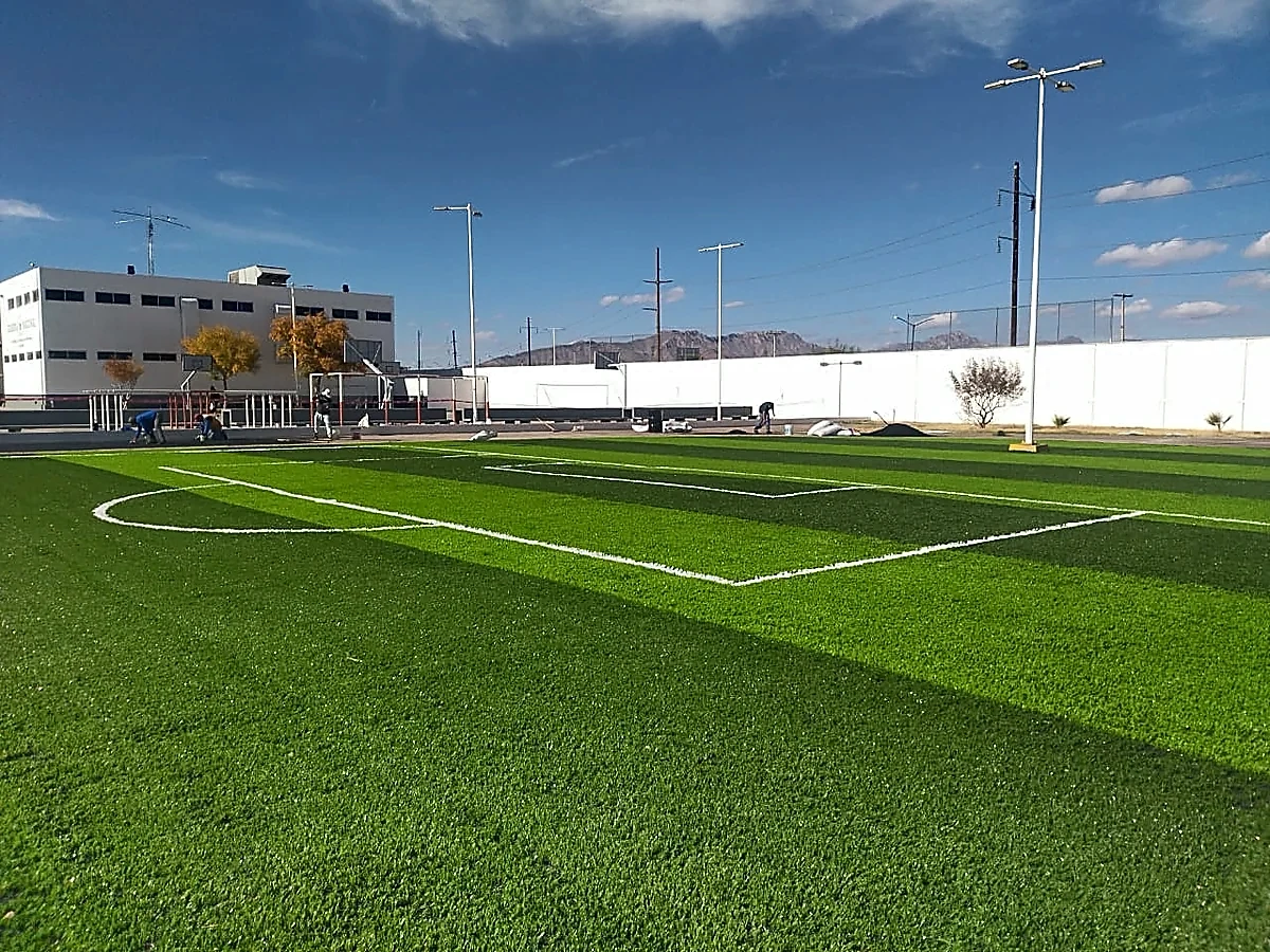 Cancha de fútbol 7 con pasto sintético en Academia de Guardia Nacional, Ciudad Juárez, Chihuahua: líneas de juego insertadas en el mismo pasto