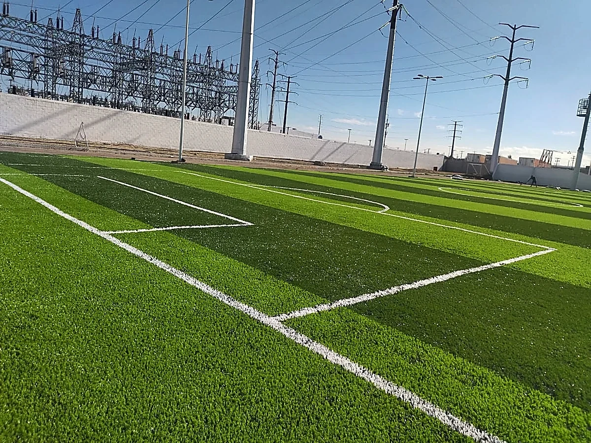 Cancha de fútbol 7 con pasto sintético en Academia de Guardia Nacional, Ciudad Juárez, Chihuahua: pasto sintético deportivo recién cepillado