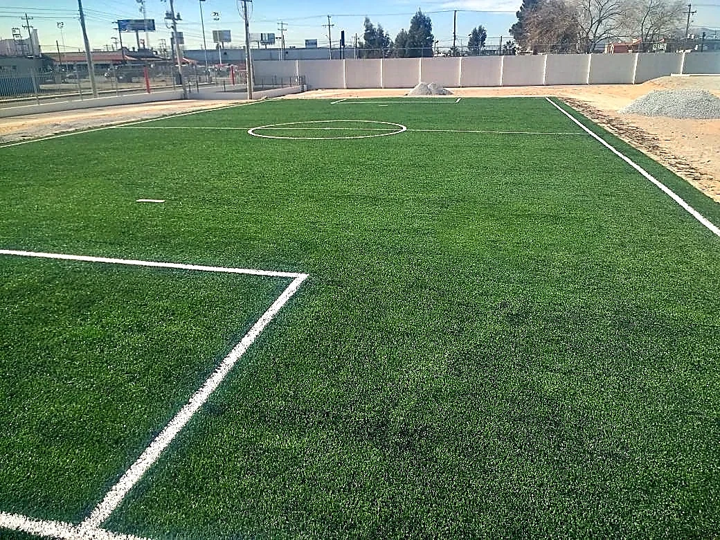 Cancha de fútbol 7 con pasto sintético en Maquila de Nexteer, Ciudad Juárez, Chihuahua: la cancha desde la línea lateral