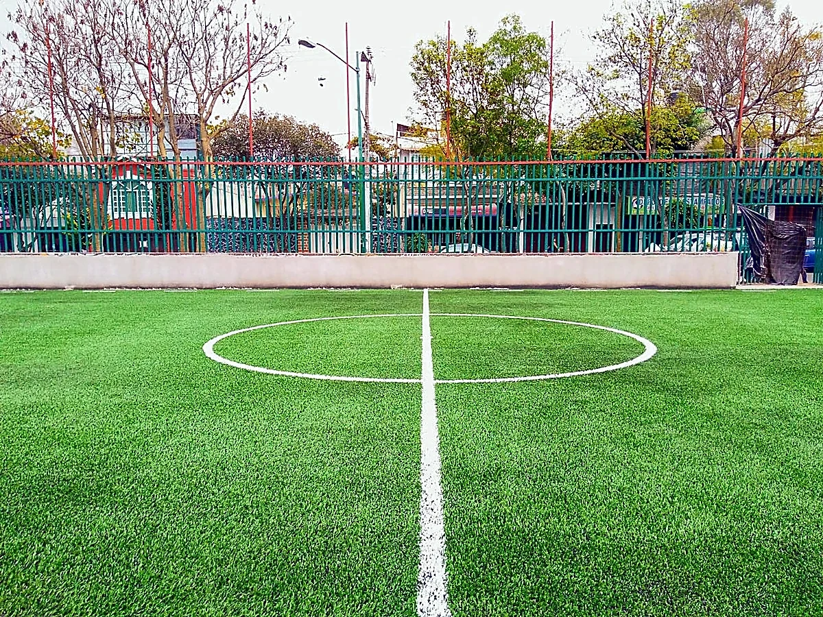 Cancha de fútbol 7 con pasto sintético en Espacio Deportivo Chicoasen, Tlalpan, Ciudad de México: líneas de juego insertadas en el mismo pasto