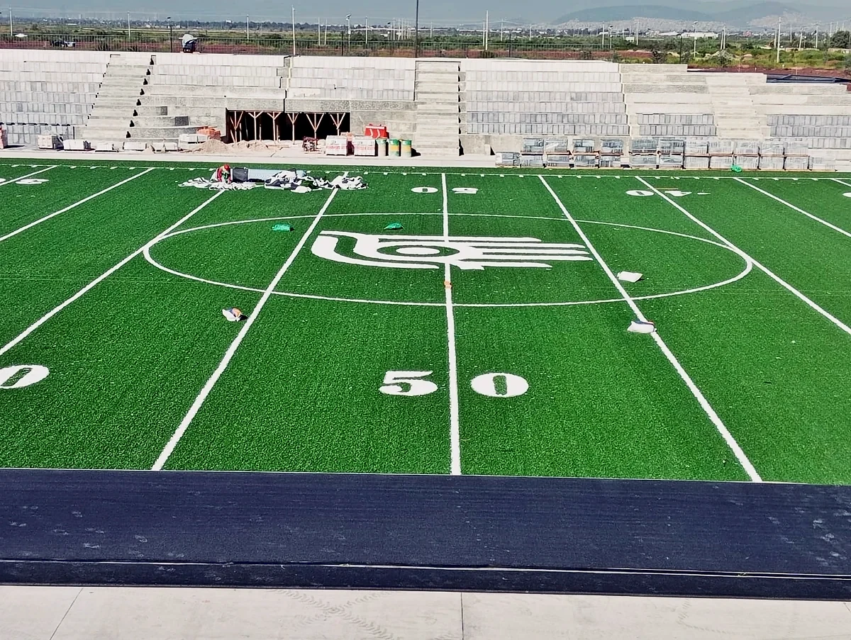 Logotipo central y yarda 50 insertados en el pasto sintético del campo de fútbol americano del Parque Ecológico Lago de Texcoco