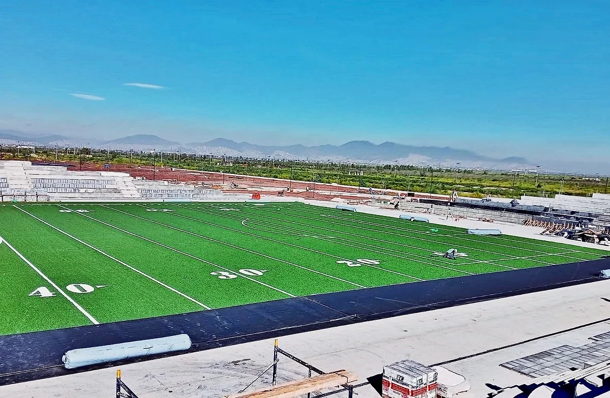 Campo de fútbol americano con pasto sintético y yardas 20, 30 y 40 insertadas con las montañas de Texcoco al fondo