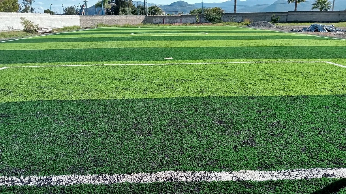 Detalle del pasto sintético de la cancha de fútbol 7 en Pilcaya, Guerrero