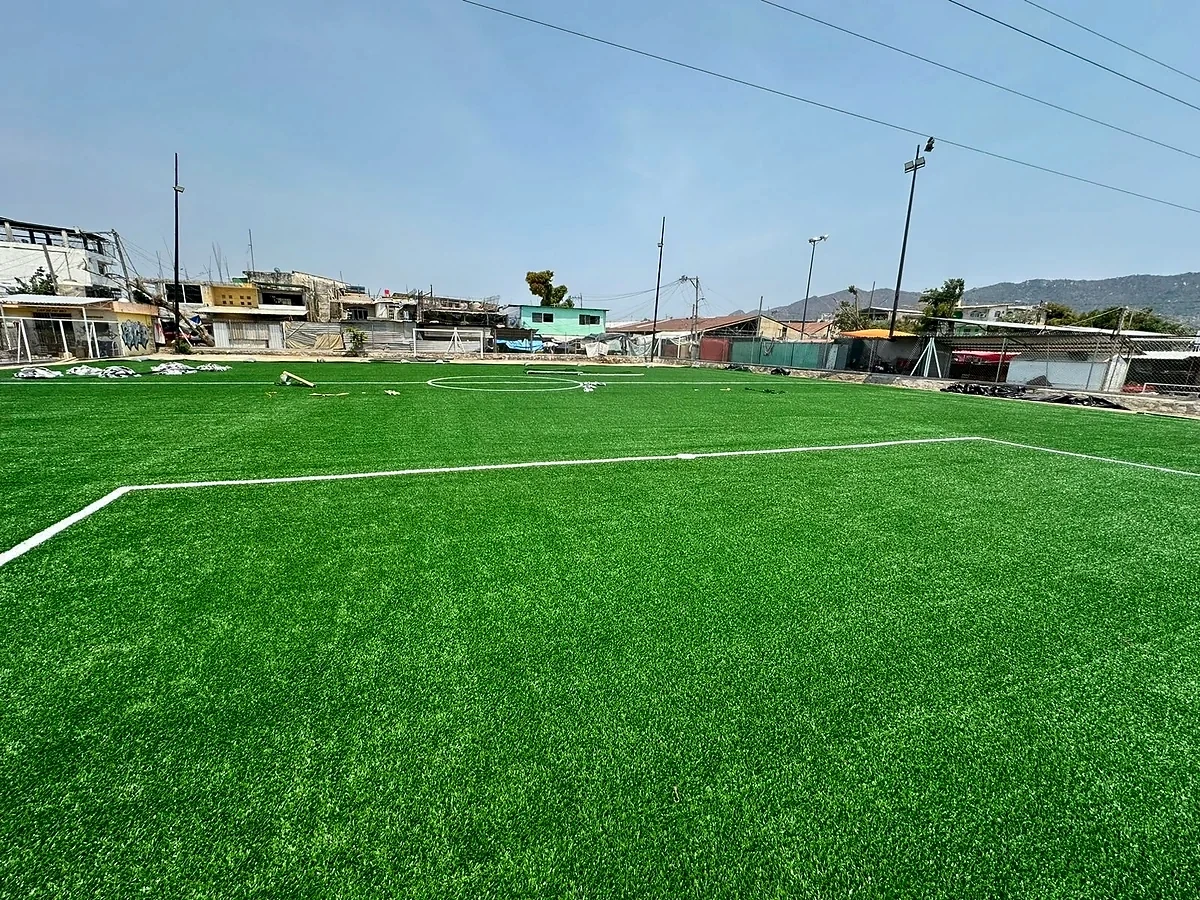 Cancha de fútbol rápido con pasto sintético en Unidad Deportiva Zapata, Acapulco, Guerrero: la cancha desde la línea lateral