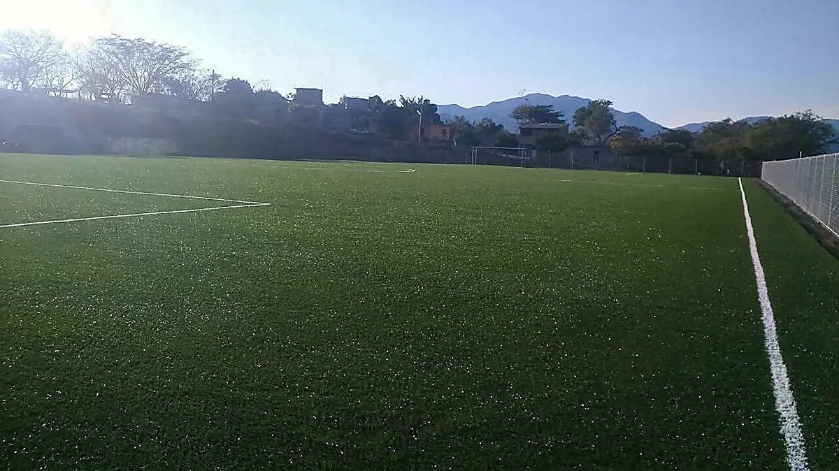 Cancha de fútbol soccer con pasto sintético en Campo deportivo de Peñoles, Apaxtla, Guerrero: la cancha desdel fondo