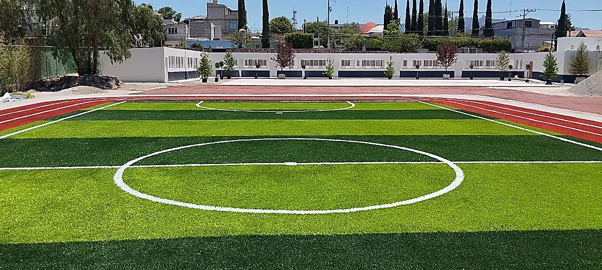 Cancha de fútbol 5 con pasto sintético en Colegio Jean Piaget de Actopan, Hidalgo: vista de la cancha y su entorno