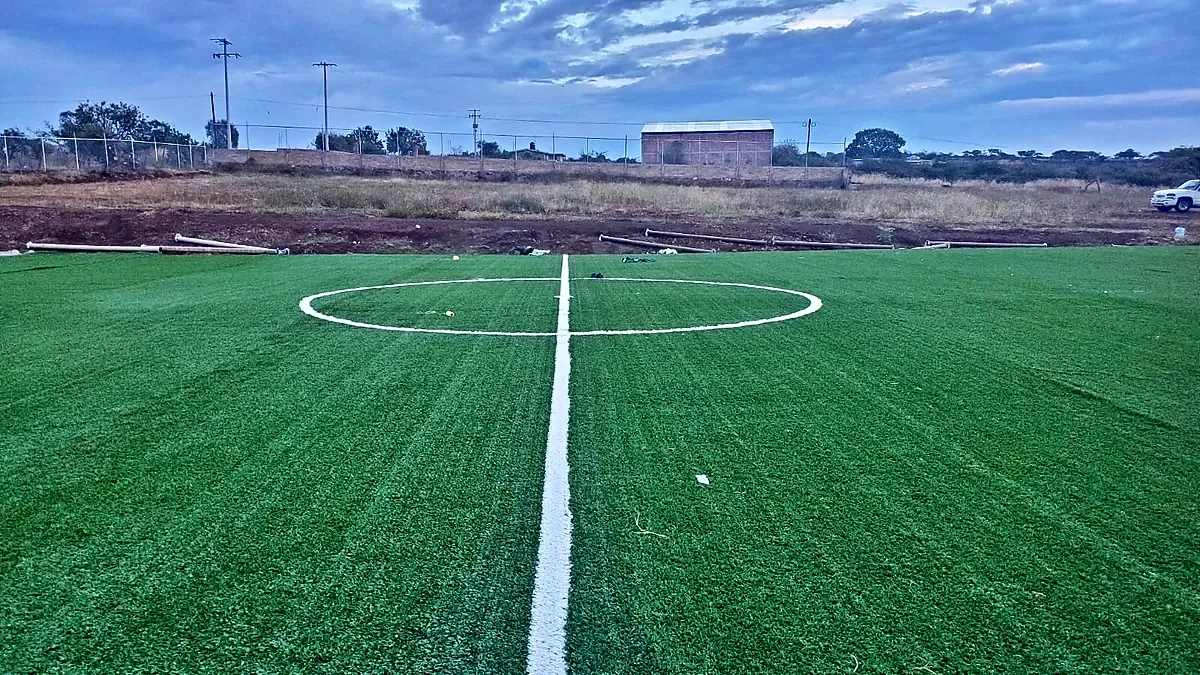 Cancha de fútbol 7 con pasto sintético en Deportivo Arellano, San José de la Paz, Jalisco: la cancha desde la línea lateral