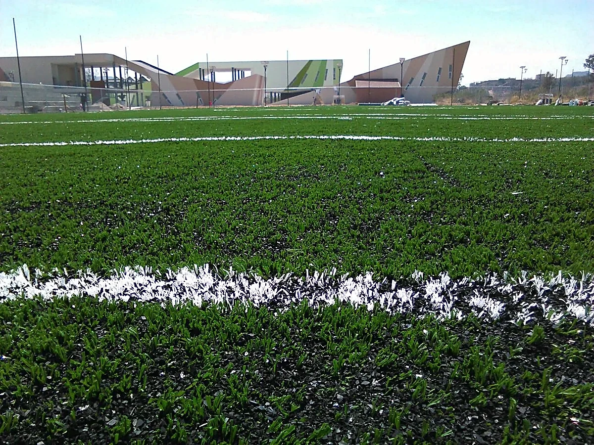 Cancha de fútbol soccer con pasto sintético en Tonalá, Jalisco: la cancha desdel fondo