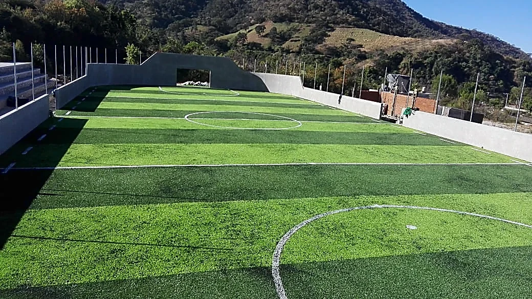 Cancha de fútbol rápido con pasto sintético en Campo Deportivo la Palma, Zitácuaro, Michoacán: líneas de juego insertadas en el pasto