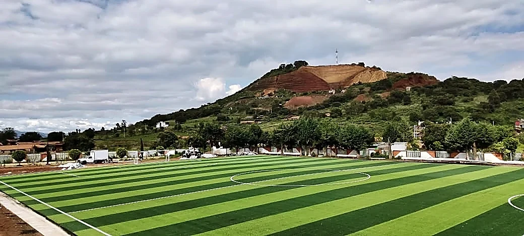 Cancha de fútbol soccer con pasto sintético en Unidad Deportiva 18 de Marzo, Tzintzingareo (Irimbo), Michoacán: otra vista de la cancha