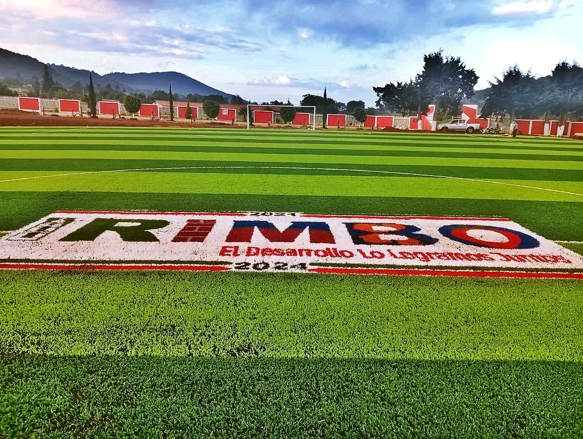 Cancha de fútbol soccer con pasto sintético en Unidad Deportiva 18 de Marzo, Tzintzingareo (Irimbo), Michoacán: la cancha desdel fondo