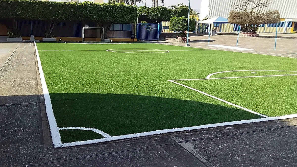 Cancha de fútbol 7 con pasto sintético en Colegio Miraflores, Cuernavaca, Morelos: pasto sintético deportivo recién cepillado