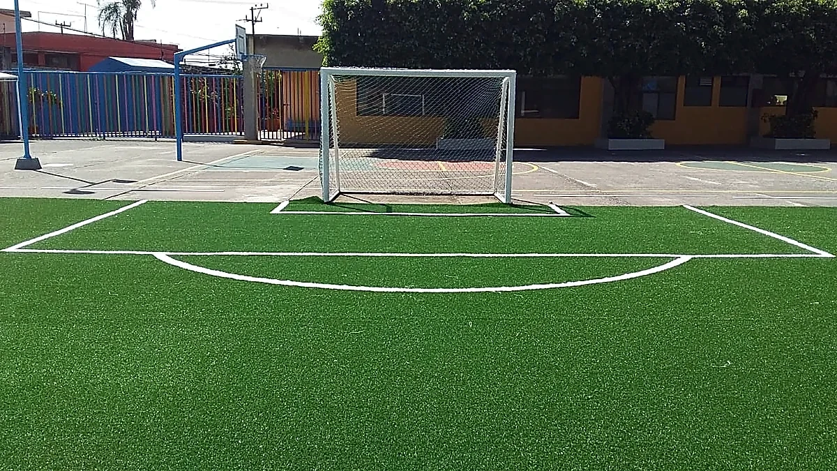 Cancha de fútbol 7 con pasto sintético en Colegio Miraflores, Cuernavaca, Morelos: la cancha desdel fondo