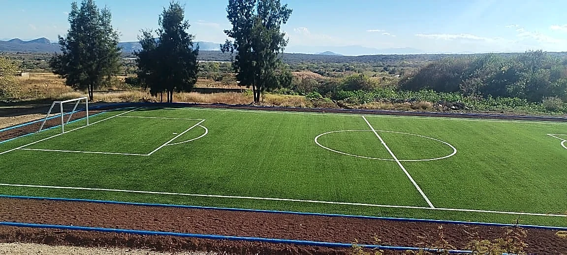 Cancha de fútbol 7 con pasto sintético en Escuela Secundaria Técnica No. 32, Tepoztlán, Morelos: líneas de juego insertadas en el mismo pasto