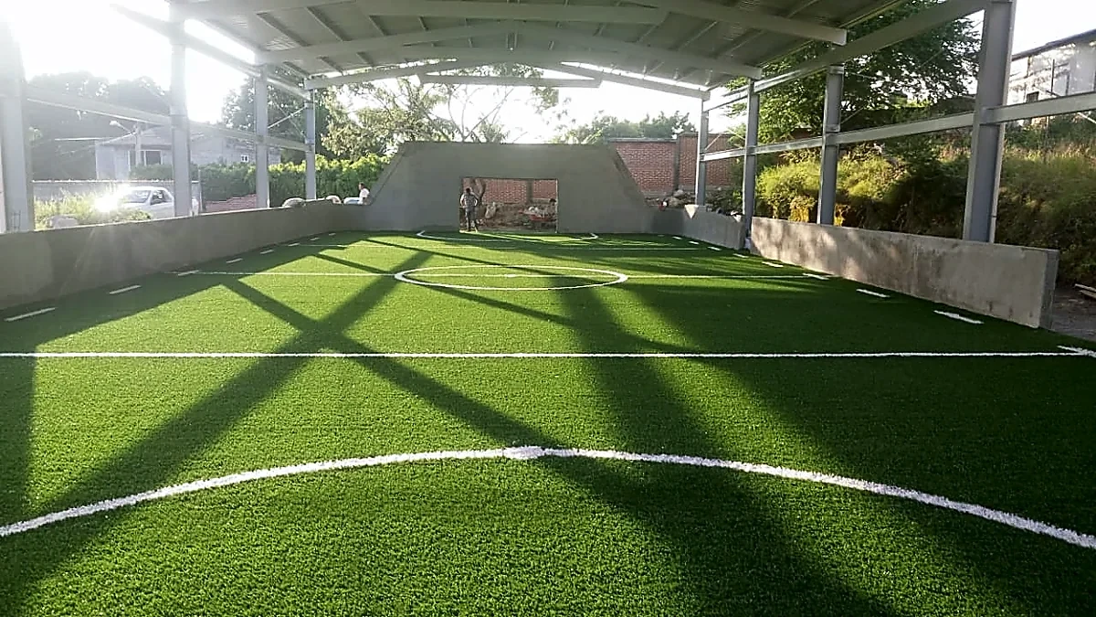 Cancha de fútbol rápido con pasto sintético en Escuela Primaria Patria Nueva, Xochitepec, Morelos: líneas de juego insertadas en el pasto