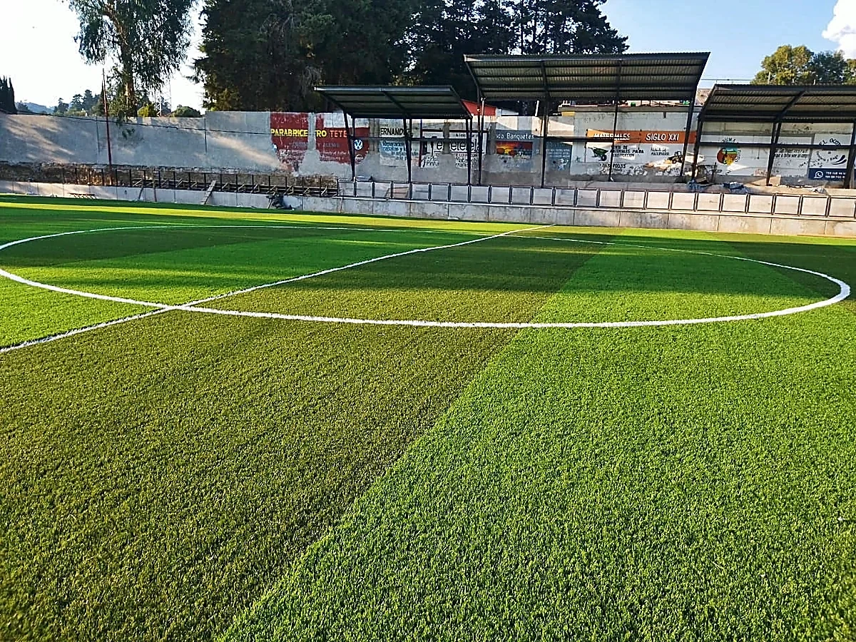 Cancha de fútbol soccer con pasto sintético en Unidad Deportiva de Tetela del Volcán, Morelos: líneas de juego insertadas en el pasto