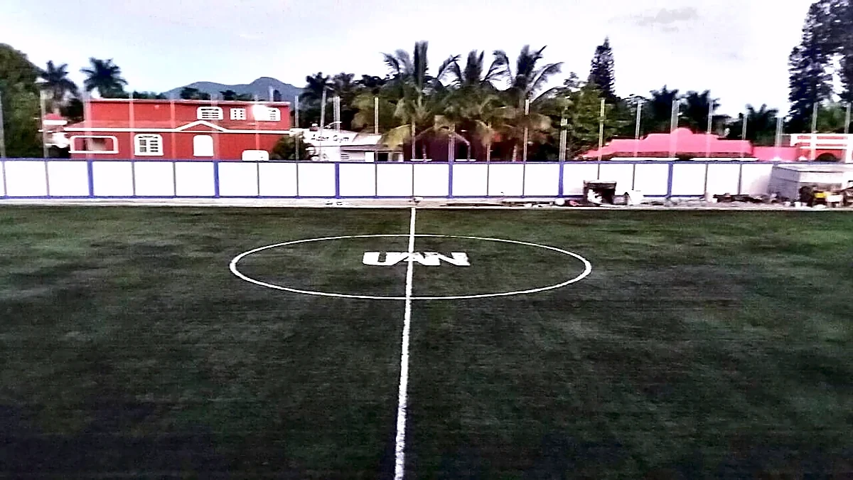 Cancha de fútbol soccer con pasto sintético en Academia Preparatoria #13, Tepic, Nayarit: la cancha desde la línea lateral