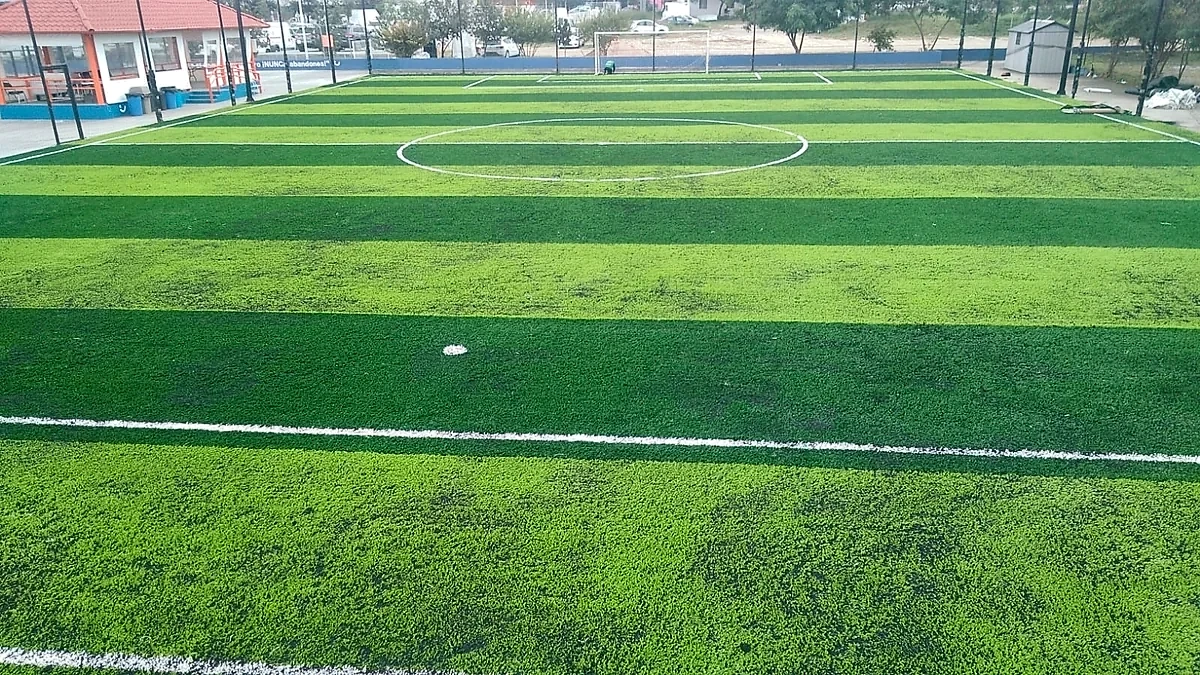 Cancha de fútbol 7 con pasto sintético en Corporativo BANREGIO, San Nicolás de los Garza, Nuevo León: líneas de juego insertadas en el mismo pasto