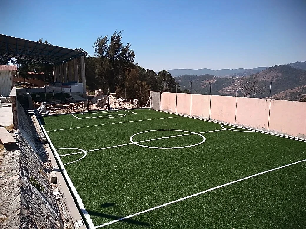 Cancha de fútbol 5 con pasto sintético en Escuela Primaria Alvaro Obregon, San Miguel el Grande, Oaxaca: la cancha desde la línea lateral