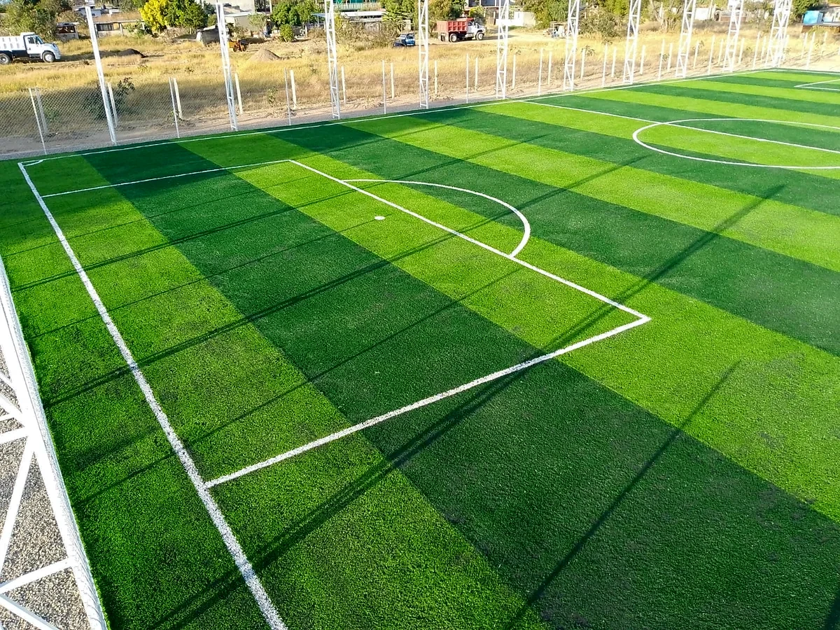 Cancha de fútbol 7 con pasto sintético en Parque Recreativo Infantil, Santiago Suchilquitongo, Oaxaca: líneas de juego insertadas en el mismo pasto
