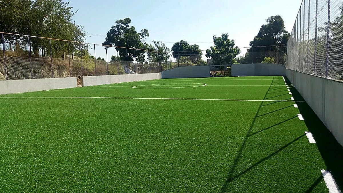 Cancha de fútbol rápido con pasto sintético en Escuela Secundaria General José A. Baños Aguirre, Santiago Pinotepa Nacional, Oaxaca: pasto sintético deportivo recién cepillado