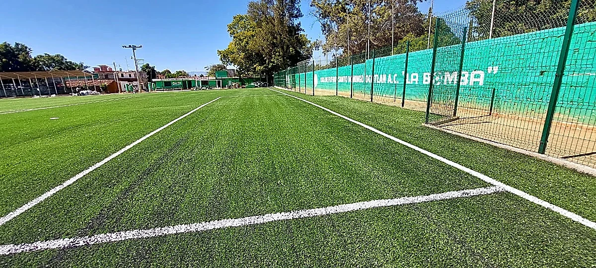 Cancha de fútbol soccer con pasto sintético en Ocotlán de Morelos, Oaxaca: vista de la cancha y su entorno