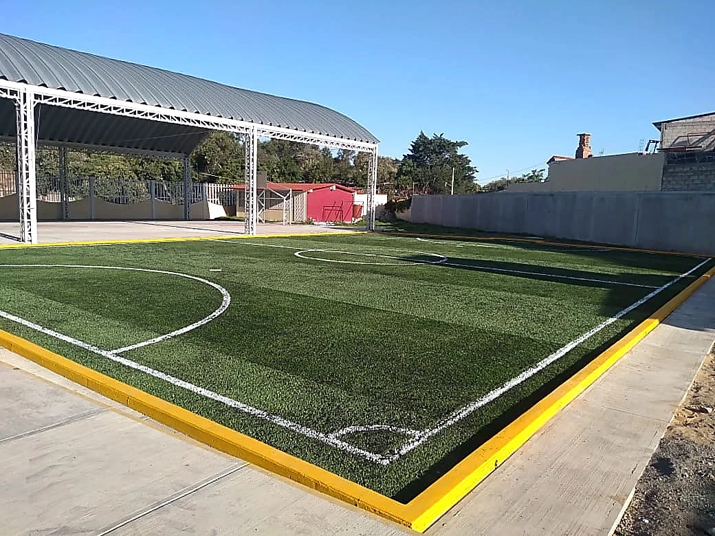 Cancha de fútbol 5 con pasto sintético en Secundaria Lic. Álvaro Gálvez, San Nicolás de los Ranchos, Puebla: líneas insertadas en el pasto sintético