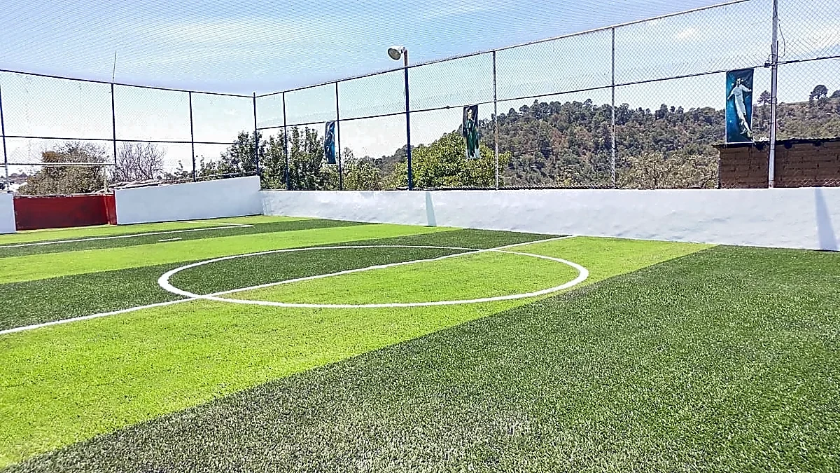 Cancha de fútbol 7 con pasto sintético en Campo Deportivo Titanes de Tlahuapan, Puebla: líneas de juego insertadas en el mismo pasto