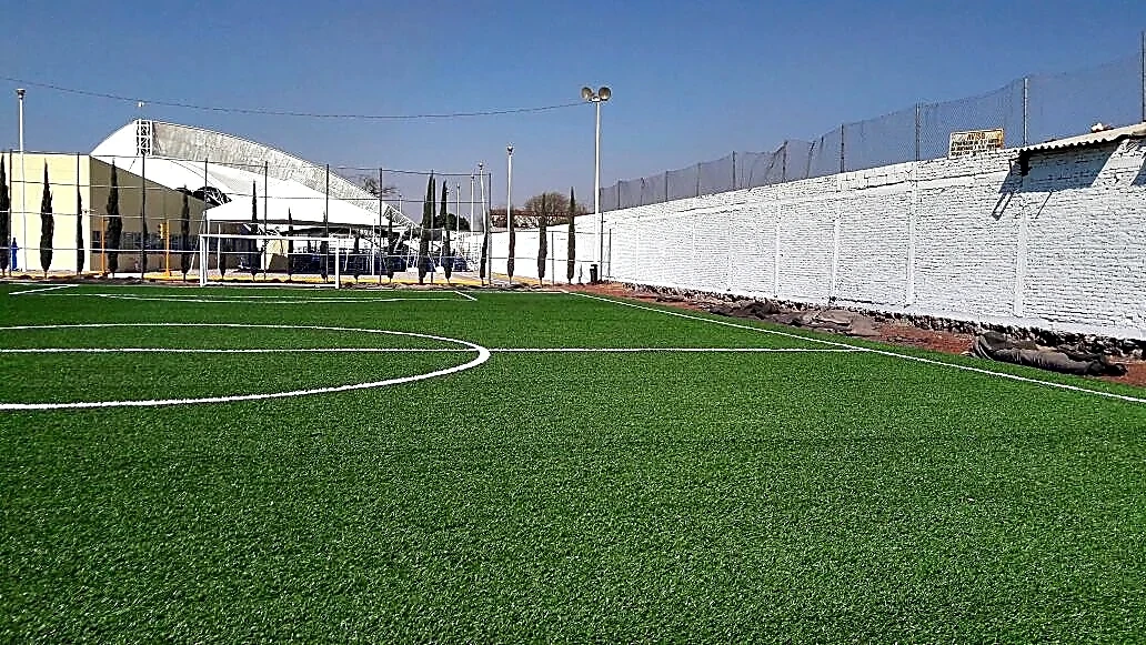 Cancha de fútbol 7 con pasto sintético en Centro Integral de Prevención y Participación Ciudadana, Puebla, Puebla: la cancha desde la línea lateral