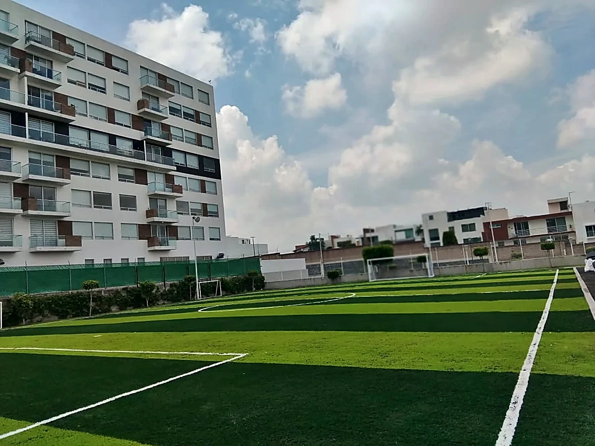 Cancha de fútbol 7 con pasto sintético en Colegio México Nuevo, Cholula, Puebla: la cancha desde la línea lateral