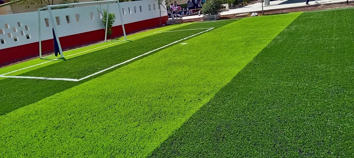 Cancha de fútbol 7 con pasto sintético en Telesecundaria Martín Luther King, San José Miahuatlán, Puebla: la cancha desdel fondo