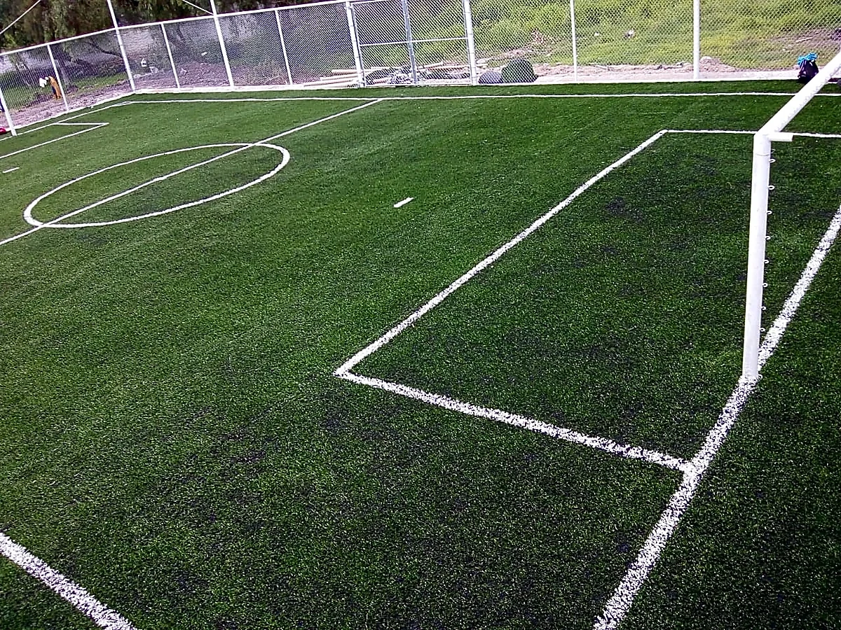 Cancha de fútbol 7 con pasto sintético en Escuela Primaria Melchor Ocampo, Querétaro, Querétaro: pasto sintético deportivo recién cepillado