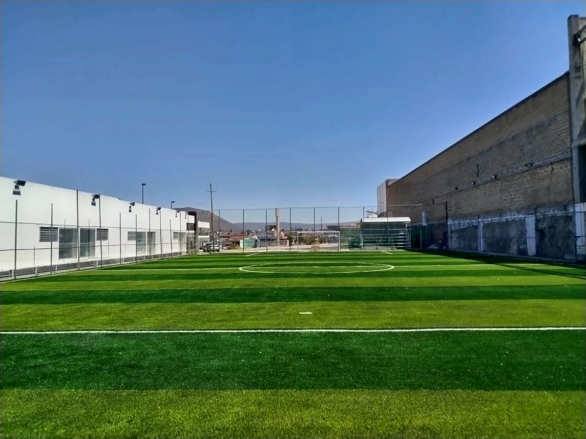 Cancha de fútbol 7 con pasto sintético en Plaza San Juan, San Juan del Río, Querétaro: la cancha desde la línea lateral