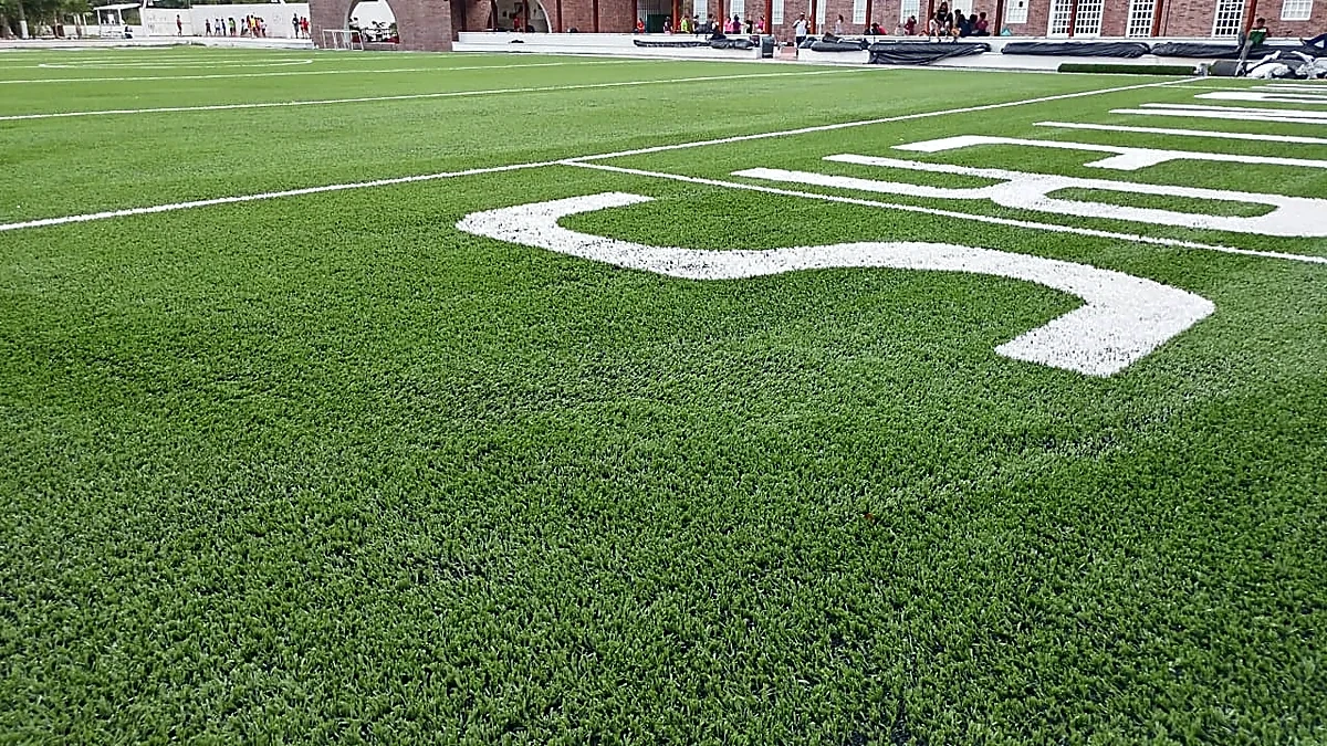 Campo de fútbol americano con pasto sintético en Colegio Álamos, Cancún, Quintana Roo: el campo y su entorno