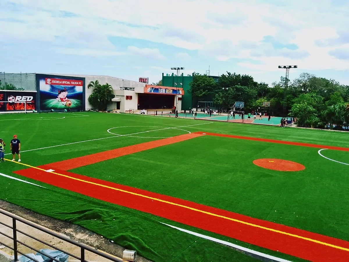 Cancha de fútbol 9 con pasto sintético en Colegio Boston, Cancún, Quintana Roo: la cancha desde la línea lateral