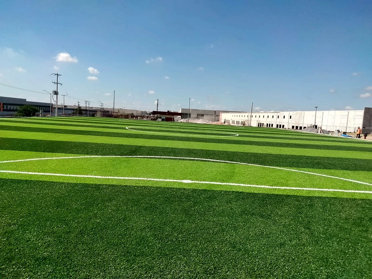 Cancha de fútbol 7 con pasto sintético en Empresa EMERSON, Reynosa, Tamaulipas: líneas de juego insertadas en el mismo pasto