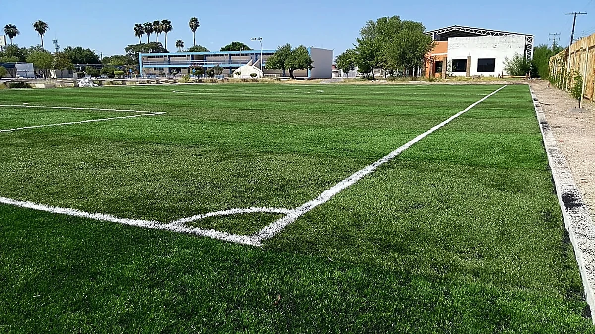 Cancha de fútbol 7 con pasto sintético en Universidad Autónoma de Tamaulipas, Nuevo Laredo, Tamaulipas: la cancha desde la línea lateral