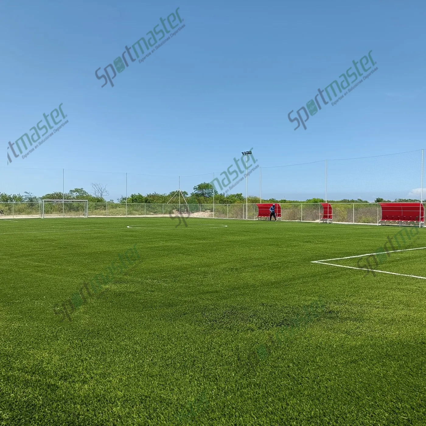 Cancha de fútbol 7 con pasto sintético y accesorios en UTMART, La Pesca, Soto La Marina, Tamaulipas: el área del fondo, las bancas y las luminarias